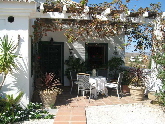 South facing entrance with covered terrace and vine grapes